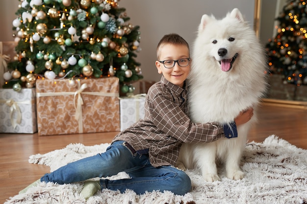 garçon avec chien près de sapin de Noël sur fond de Noël