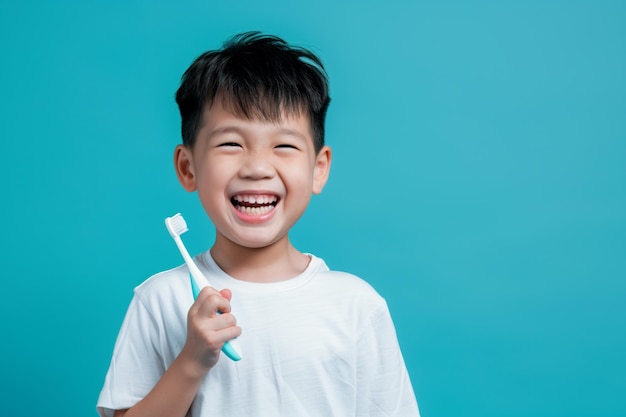 Un garçon chinois avec une brosse à dents à la main sur un fond bleu clair