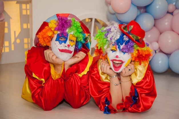 Garçon clown avec fille clown s'amusant à la maison de vacances