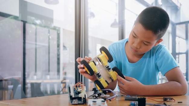 Garçon Concentré Créant Un Robot Au Laboratoire.