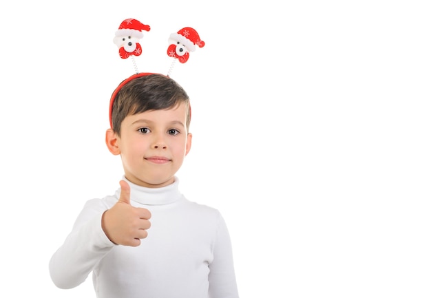 Garçon avec des cornes de jouet sous forme d'ours de Noël montre un geste cool sur fond blanc isolé