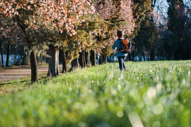 garçon courant dans le champ entre les arbres en fleurs