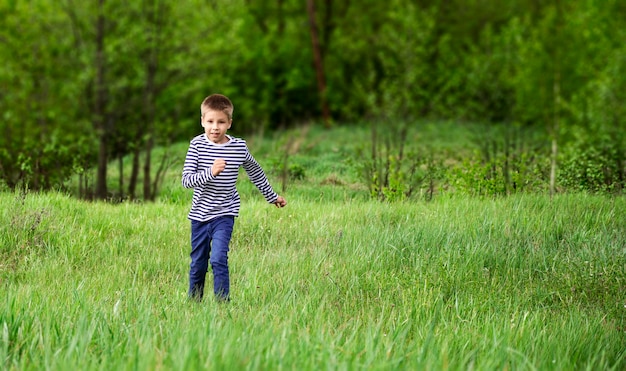 Garçon courant sur l'herbe à l'extérieur