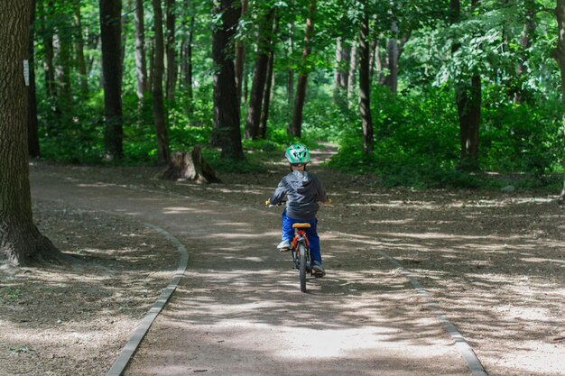 Garçon dans un casque sur un vélo dans le parc