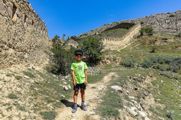 Un garçon dans le contexte de la forteresse de Gunib Un mur de protection Russie Daghestan juin 2021