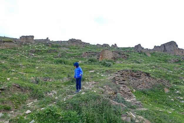 Un garçon dans les tours défensives médiévales de l'ancien village de Goor Russie Daghestan 2021