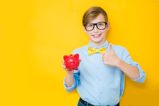 Garçon dans des verres avec tirelire sur fond jaune espace pour le texte Entreprise et économiser de l'argent concept Banque publicité finance