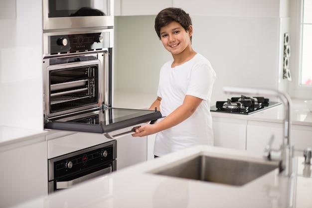 Un garçon debout dans la nouvelle cuisine moderne