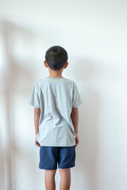 Garçon debout devant le mur dans le coin de la piècePar être puni par ses parents.