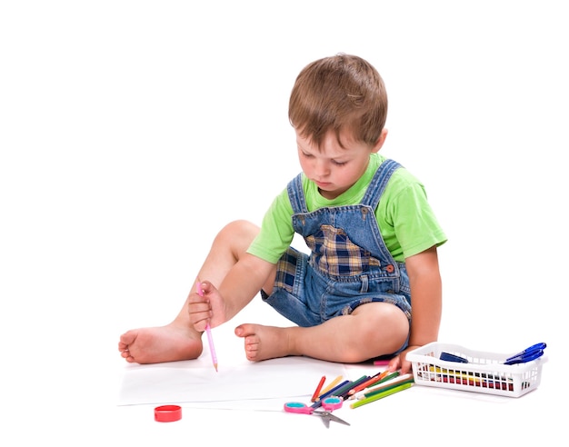 Le garçon dessine un crayon se reposant sur le plancher