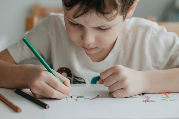 Le garçon dessine avec des crayons au gros plan de la cuisine Photo de haute qualité