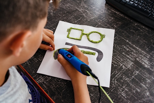 Le garçon dessine la poignée de lunettes 3d