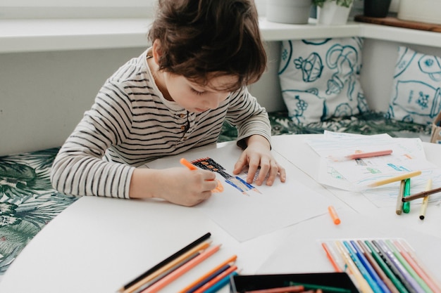 Le garçon dessine avec des stylos de feutre photo de haute qualité