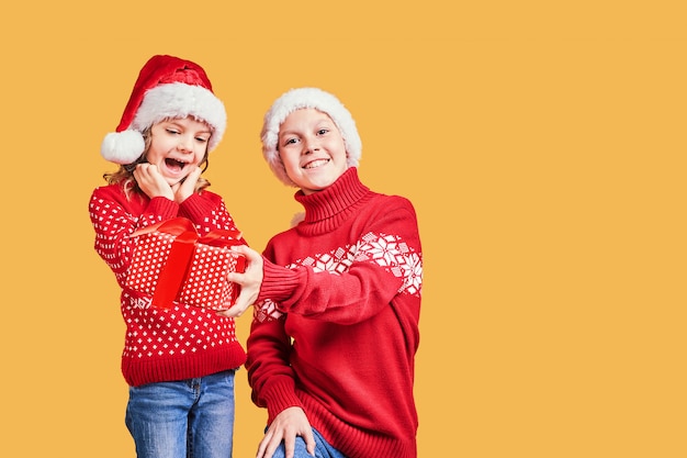 Garçon distribuant un cadeau de Noël à une fille surprise