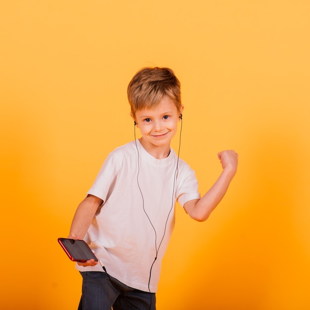 Garçon d'émotions écoute de la musique avec des écouteurs sur son téléphone, fond jaune. Contes de fées pour enfants dans les écouteurs.