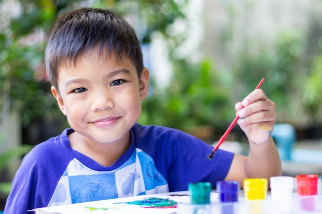 Garçon enfant asiatique dessin et peinture de couleurs sur le papier dans la salle.