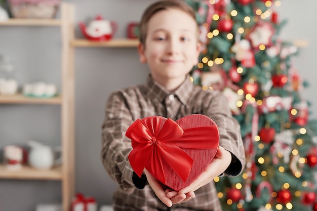 Garçon enfant avec boîte-cadeau et arbre de Noël.