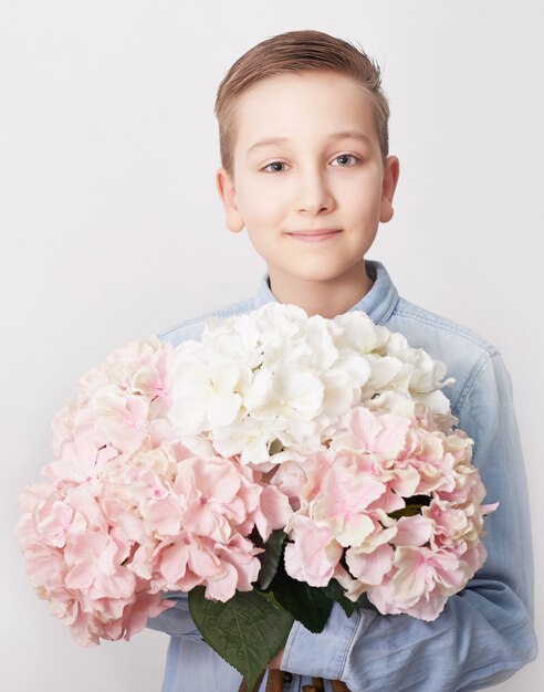 Garçon enfant avec bouquet de fleurs. Fête des mères