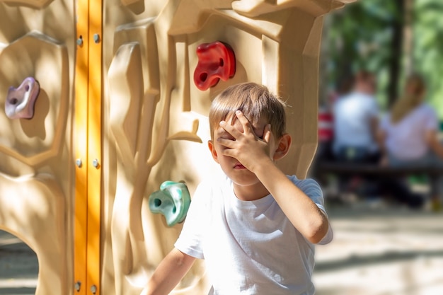 Garçon enfant mignon bouleversé assis après une chute