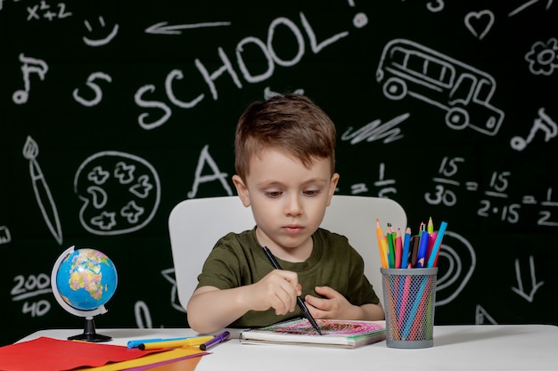 Garçon enfant mignon à faire ses devoirs.