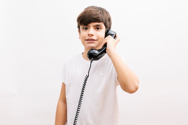 Garçon enfant parlant au téléphone vintage