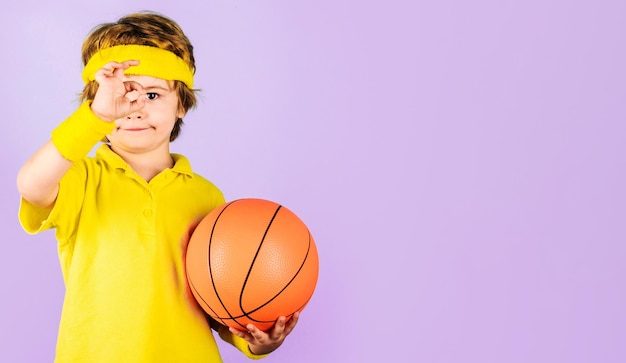 Garçon enfant sportif avec ballon de basket-ball montrant un signe correct sport pour enfants petit joueur de basket-ball