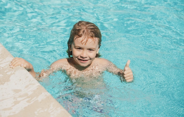 Garçon enfant avec Thumbs up nager dans la piscine