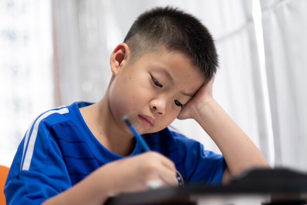 garçon d'enfants à faire leurs devoirs, papier d'écriture kid, concept de famille, temps d'apprentissage, étudiant, retour à l'école