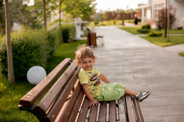 le garçon est assis seul sur un banc