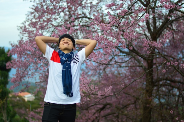 Le garçon est heureux de voir les cerisiers en fleurs.