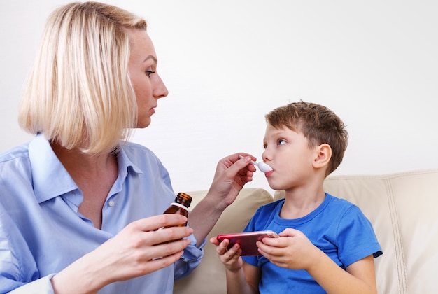 Le garçon est malade. Maman traite des drogues