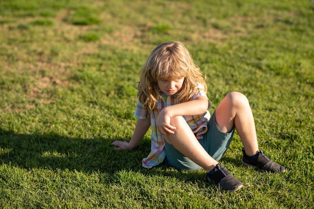 Un garçon est tombé lors d'une promenade dans le parc un enfant au genou cassé dans le parc enfant au genou cassé en plein air