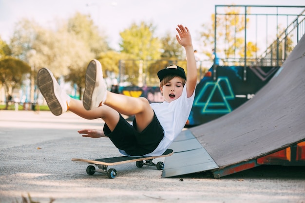 Un garçon exécute des tours sur une planche à roulettes dans une zone spéciale du parc.