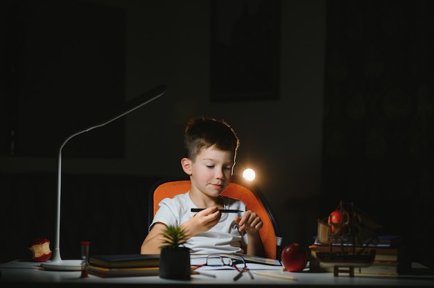 Garçon à faire ses devoirs à la maison en soirée