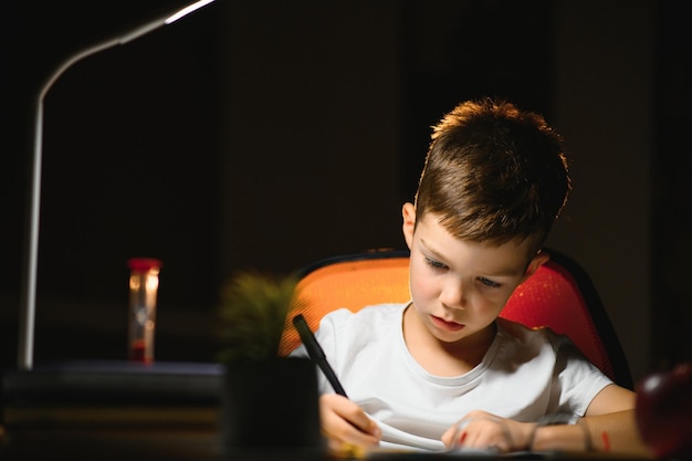 Garçon à faire ses devoirs à la maison en soirée