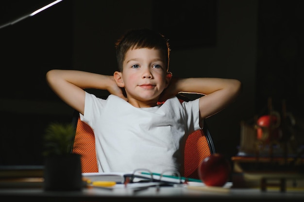 Garçon à faire ses devoirs à la maison en soirée