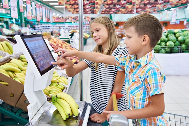 Garçon et fille achetant des bananes en magasin