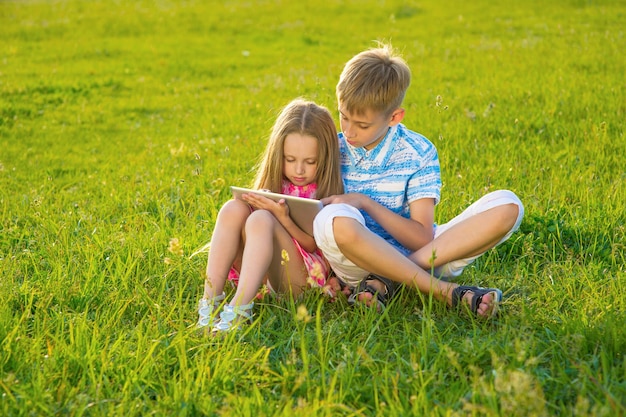 Garçon avec fille assise sur la pelouse.