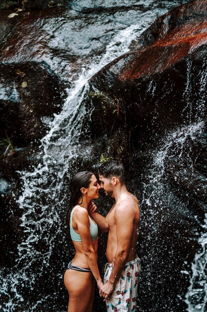 Garçon et fille couple ensemble sous une petite cascade