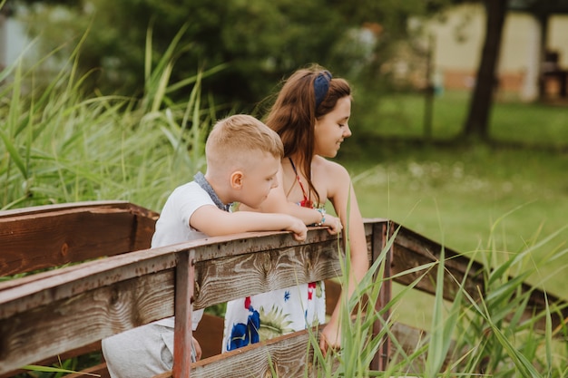 Photo garçon et fille debout sur une jetée en bois, vacances d'été