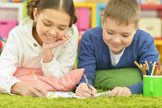 Un garçon et une fille dessinent avec des crayons