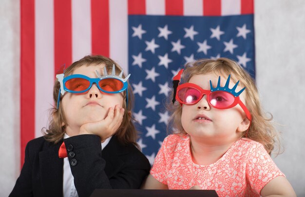 Garçon et fille devant le drapeau américain. Fermer