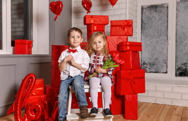 Garçon et fille donnent un cadeau le jour de la Saint-Valentin jeune couple s'embrassant