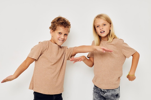 Garçon et fille gesticulent avec leurs mains ensemble enfance inchangée