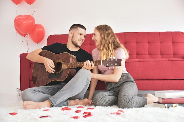 Garçon fille jouant de la guitare dans la chambre bonheur romantique amoureux Saint Valentin