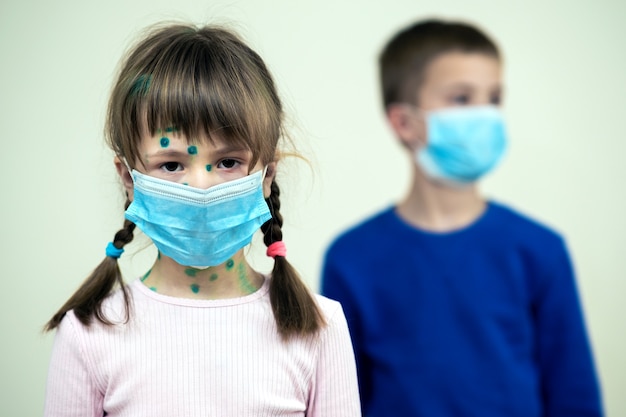 Garçon et fille portant des masques médicaux de protection bleus