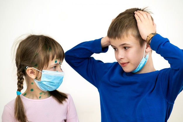 Garçon et fille portant des masques médicaux de protection bleus