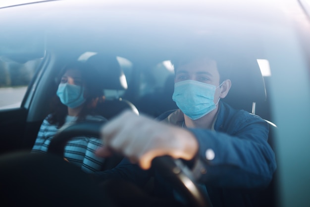 Garçon et fille portent un masque médical stérile protecteur dans la voiture. Covid 19.