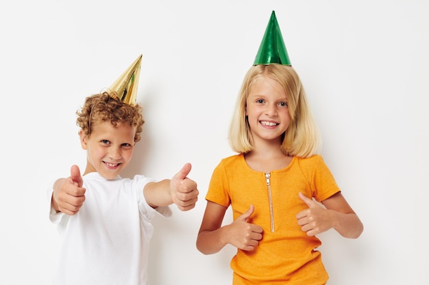 Garçon et fille posant des émotions vacances casquettes colorées fond isolé inchangé