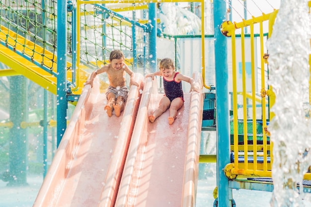 Garçon et fille s'amusent dans le parc aquatique.